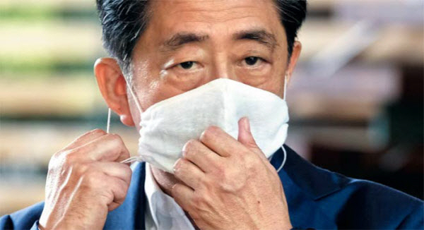 아베 신조 일본 총리가 24일 게이오대 병원에서 추가 검사를 받은 뒤 도쿄 총리 관저로 출근하면서 취재진의 질문에 답하기 위해 마스크를 벗고 있다. /AFP연합뉴스