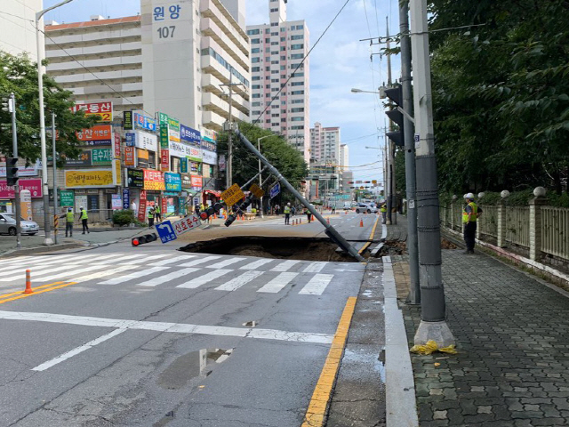 26일 오후 경기도 구리시 수택동 한양아파트 인근 도로에서 발생한 땅 꺼짐 현상(싱크홀)으로 신호등이 쓰러져 있다. /연합뉴스