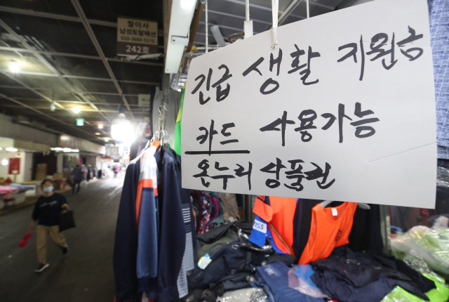 지난 5월 서울 종로구 광장시장의 한 상점에 긴급재난지원금 사용 가능 안내문이 붙어 있다./연합뉴스