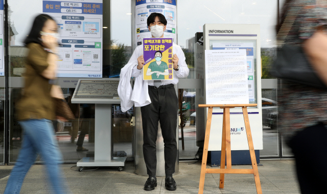 한 서울대 의대생이 지난  20일 정부의 의료정책에 반대하는 손팻말을 들고 서울대병원 본관 앞아서 릴레이 1인 시위를 하고 있다. /연합뉴스