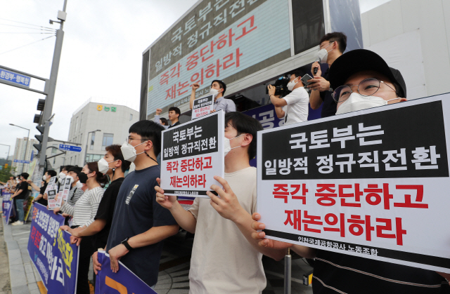 인천국제공항공사노동조합 관계자들이 지난 12일 오전 세종시 정부세종청사 국토교통부 앞에서 ‘인국공사태’ 해결 촉구 집회를 열고 정규직 전환 재논의를 촉구하는 손팻말을 들고 있다./연합뉴스