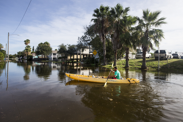27일(현지시간) 초강력 허리케인 로라의 영향권에 든 미국 텍사스주의 한 거리가 물에 잠기자 한 남성이 카누를 이용해 이동하고 있다./AP연합뉴스