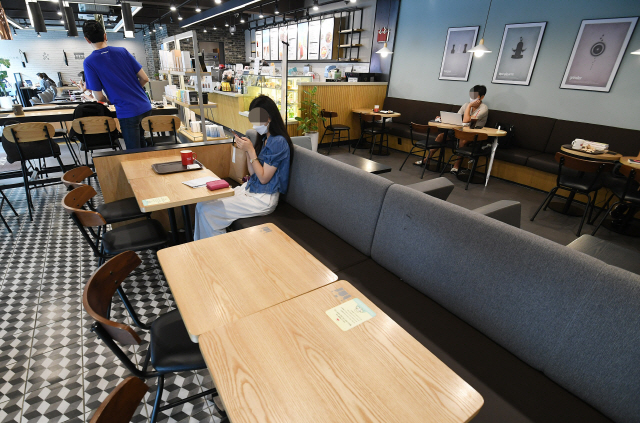 정부가 ‘사회적 거리두기’ 2단계 강화 조치를 발표한 28일 오후 서울시내의 한 대형 프랜차이즈 커피전문점에서 손님들이 거리를 둔 채 앉아 매장을 이용하고 있다.  /오승현기자