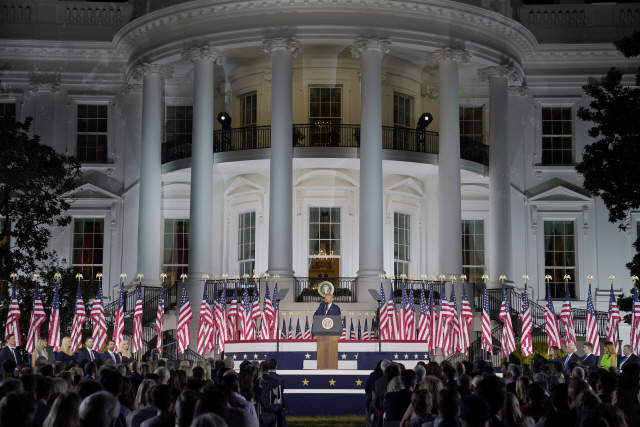 백악관을 배경으로 수십개의 성조기로 가득찬 무대에 올라 선 도널드 트럼프 미국 대통령./AP연합뉴스