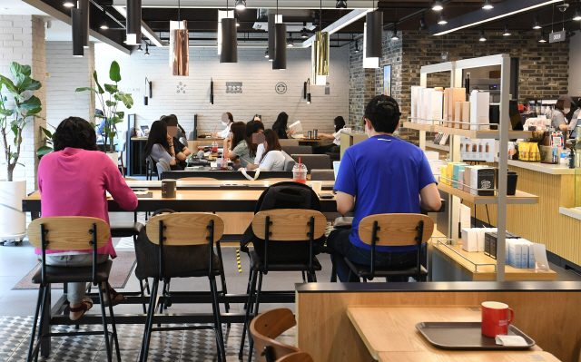 정부가 ‘사회적 거리두기’ 2단계 강화 조치를 발표한 28일 오후 서울시내 한 대형 프랜차이즈 커피전문점에서 손님들이 거리를 둔 채 앉아 매장을 이용하고 있다./오승현기자