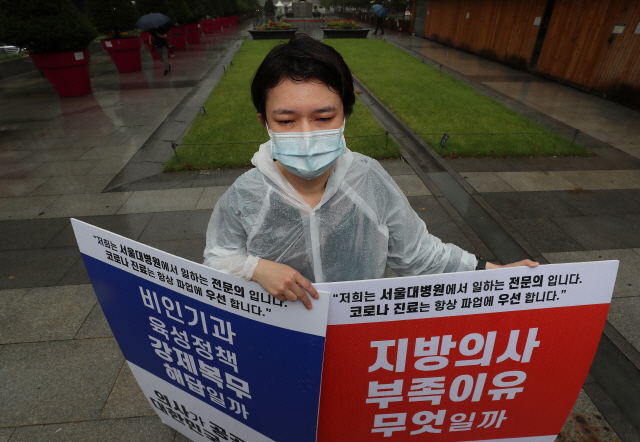 29일 오전 서울 광화문광장 이순신 동상 앞에서 서울대학교 병원 전문의가 정부의 의료정책에 반대하며 1인 시위를 하고 있다. /연합뉴스