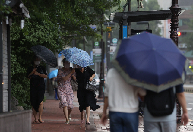 서울 지역에 비가 내린 29일 오전 서울 종로구 대학로 일대에서 시민들이 우산을 쓰고 이동하고 있다. /연합뉴스