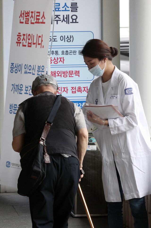 지난 27일 서울 여의도 성모병원에서 파업 중인 한 전공의가 내원객에게 공공의료의 문제점을 알리고 있다./