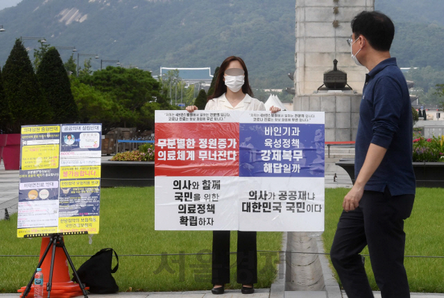 30일 서울 광화문광장 앞에서 신촌세브란스 병원 소속 전문의가 정부 의료정책 반대 1인 시위를 하고 있다. 대한전공의협의회(대전협) 비상대책위원회는 전날 오후부터 이날 오전까지 이어진 회의 끝에 파업을 강행하기로 결정한 것으로 전해졌다./권욱기자 2020.8.30