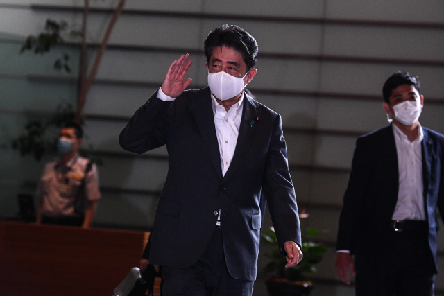아베 신조 일본 총리가 31일 도쿄 총리관저로 출근하면서 취재진에게 인사하고 있다.   　 /AFP연합뉴스