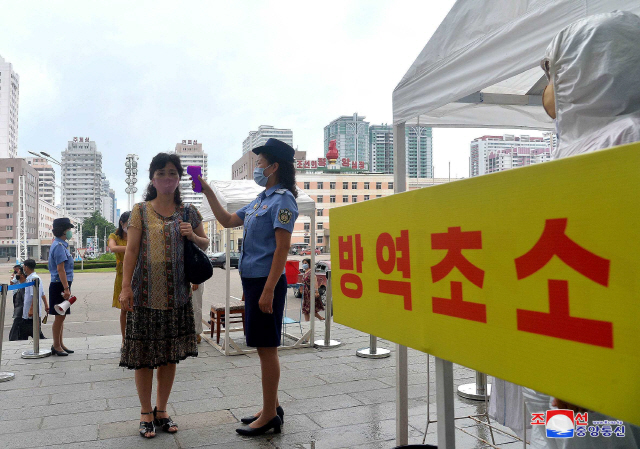 북한 평양역에서 직원들이 신종 코로나바이러스 감염증(코로나19)의 확산을 막기 위해 체온을 측정하는 모습. /연합뉴스