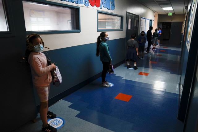 지난달 26일(현지시간) 미국 LA의 한 학교에서 학생들이 코로나19 확산을 막기 위해 점심시간동안 사회적 거리두기를 유지한 채 줄을 서 있다. /AP연합뉴스