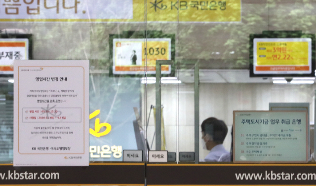 코로나19 재확산 방지를 위해 6일까지 은행 영업시간을 단축하기로 한 1일 서울 국민은행여의도본점에 안내문이 붙여져 있다. 은행 영업시간은 오전 9시 30분~오후 3시 30분으로 1시간 단축됐다./연합뉴스