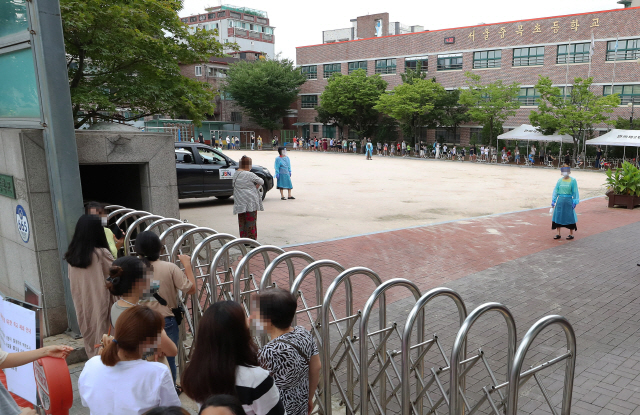 이달 1일 오후 서울 중랑구 중목초등학교 운동장에 마련된 선별진료소에서 학생들이 코로나19 검사를 받기 위해 차례를 기다리고 있다. /연합뉴스