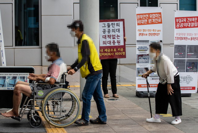 정부의 의과대학 정원 확대, 공공의대 설립 등에 반대해 집단휴진에 나선 전공의가 2일 서울 신내동 서울의료원 입구에서 손팻말을 들고 시위하고 있다. /연합뉴스