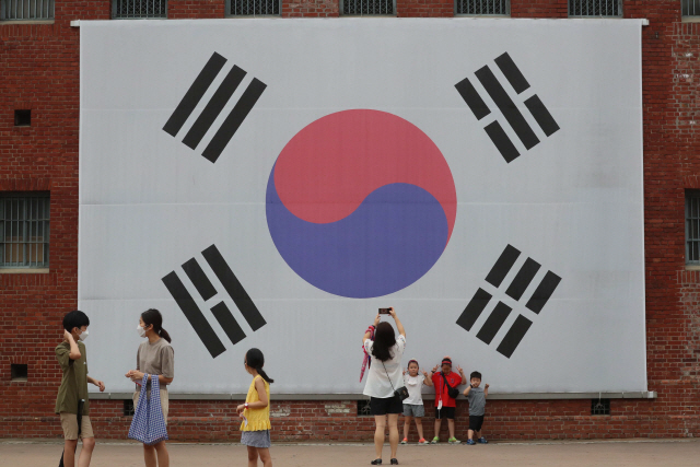 제75주년 광복절을 하루 앞둔 8월 14일 서울 서대문독립공원 내 대형태극기 앞에서 시민들이 사진을 찍고 있다./권욱기자