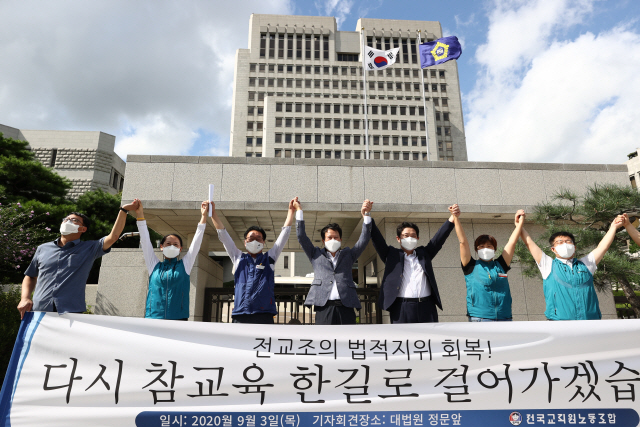 권정오 전국교직원노동조합(전교조) 위원장과 조합원들이 3일 오후 서초동 대법원에서 열린 법외노조 통보 처분 취소 소송 상고심 선고를 마치고 법정을 나와 만세를 외치고 있다. /연합뉴스