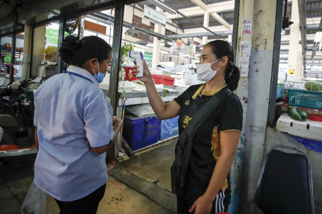지난 2일 태국 방콕에서 코로나19 확산을 막기 위해 식료품점에 들어가려는 손님의 체온을 측정하고 있다. /EPA연합뉴스