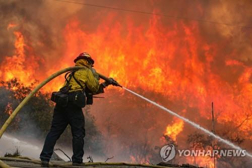 6일(현지시간) 미 캘리포니아주 샌디에이고카운티의 하물에서 발생한 ‘밸리파이어’를 소방관이 진화하고 있다./AP연합뉴스