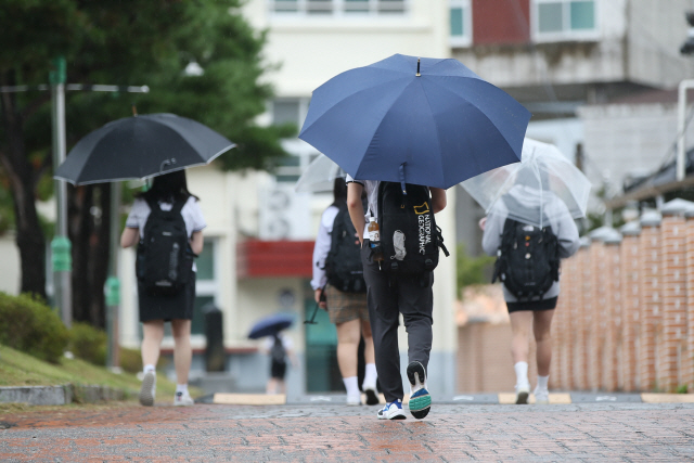 제10호 태풍 ‘하이선’의 영향권에 든 7일 오전 전남 구례군 구례읍 구례고등학교에서 학생들이 우산을 쓰고 등교하고 있다. /구례=연합뉴스