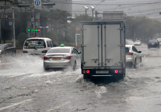 태풍 하이선이 동해안을 강타한 7일 오전 부산 센텀시티 일대가 물에 잠겨 차량이 힘겹게 통행하고 있다./연합뉴스
