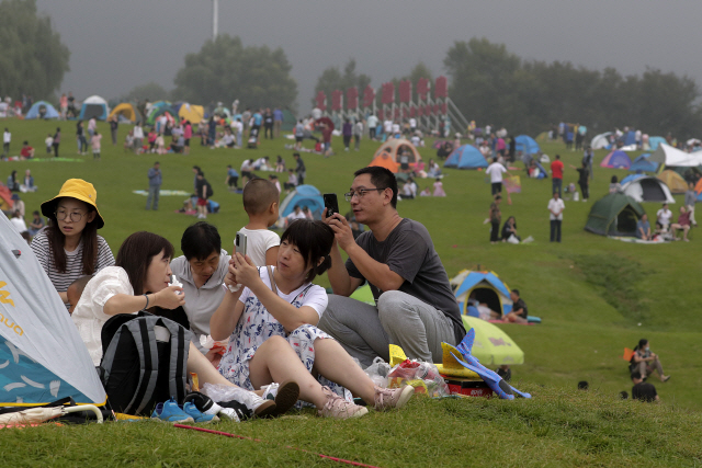 지난달 30일(현지시간) 중국 수도 베이징 외곽의 관광도시 옌칭에서 마스크를 쓰지 않은 시민들이 캠핑하며 휴일을 즐기고 있다./AP연합뉴스