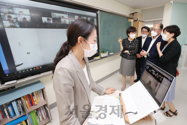 8일 오전 서울 서초구 서울교대부설초등학교 6학년 교실에서 KT 커스터머부문장 강국현 부사장과 임유원 서울시교육청 교육연구정보원장, KT 커스터머신사업본부장 김훈배 전무, 이계수 서울교대부설초등학교 교장이 KT 온라인 교육 플랫폼을 활용한 원격 수업을 참관하며 의견을 나누고 있다. KT가 이번에 구축한 온라인 교육 플랫폼은 실시간 화상 수업, 수업 교재 제작 및 관리, 출결이나 과제 등의 학사 관리까지 원격 수업에 필요한 모든 기능을 통합적으로 제공하는 원스톱 통합 플랫폼이다. /사진제공=KT