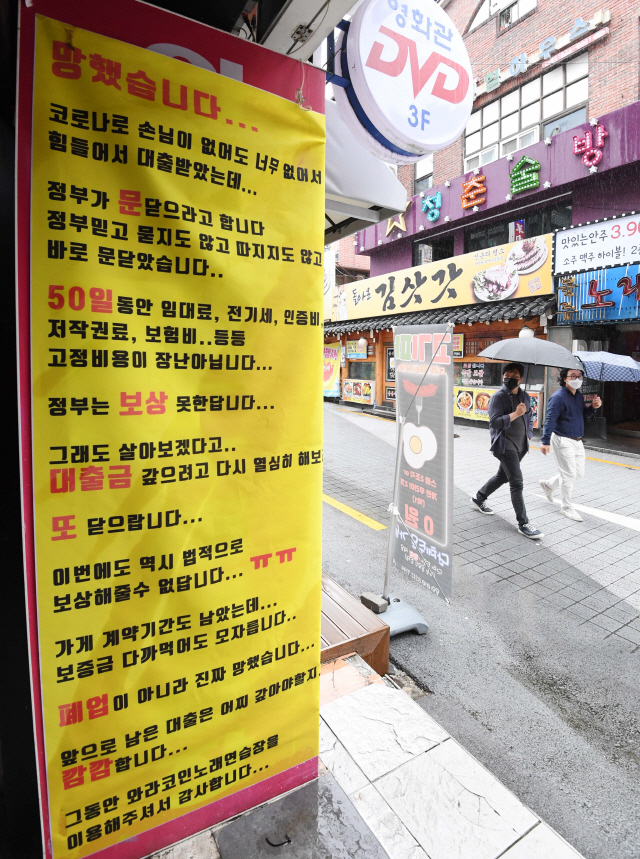 코로나19 확산으로 사회적거리두기 2.5단계가 시행되고 있는 7일 서울 신촌의 한 노래연습장 앞에 영업 중단을 알리는 현수막이 붙어 있다./권욱기자