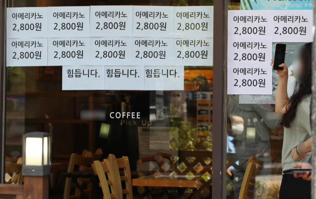 최근 수도권의 코로나19 확산으로 강화된 2단계 사회적 거리두기로 자영업자들의 시름이 깊어지는 가운데 서울의 한 커피 전문점에 ‘힘듭니다’라는 문구가 적혀 있다. /연합뉴스