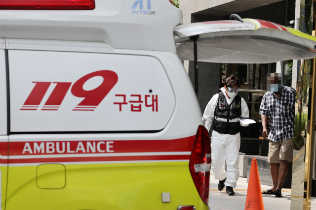 지난달 17일 생활치료센터로 지정된 서울 시내 한 호텔에서 무증상 격리자가 다른 신체 치료를 위해 119구급차량으로 이송되고 있다./연합뉴스
