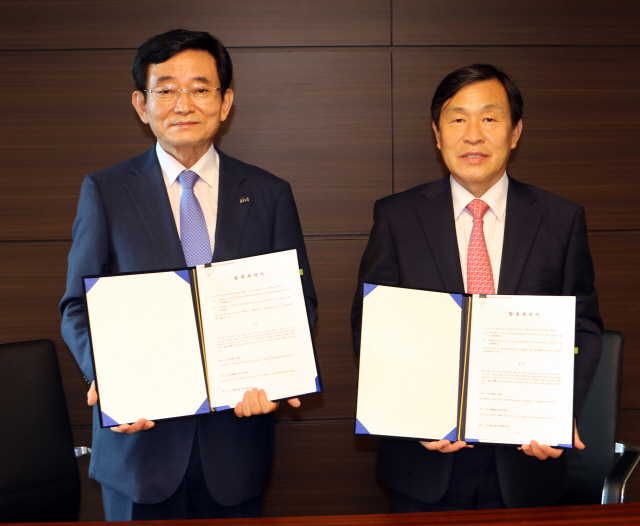 김내환(왼쪽) KCC글라스 대표이사와 우종철 코리아오토글라스 대표이사가 9일 합병 계약을 체결한 후 계약서를 내보이고 있다. /사진=KCC