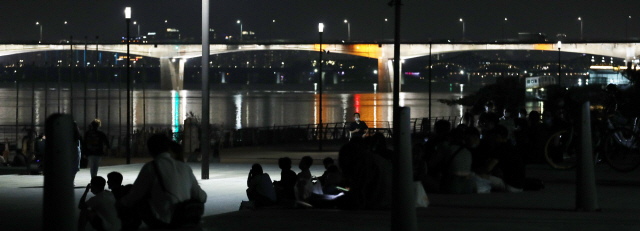 지난 8일 밤 마포대교 인근 한강공원에 시민들이 모여 있다./연합뉴스