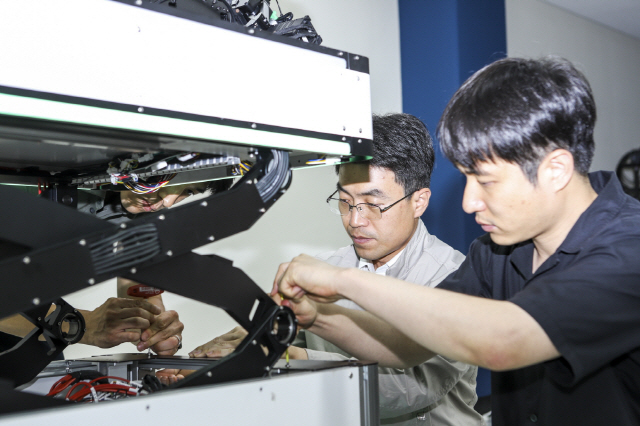 한국기계연구원 인공지능기계연구실 김창현(사진 왼쪽) 실장과 연구진이 모듈형 AI 기반의 자율 작업 로봇에 상하 이동이 가능한 리프트 모듈을 장착하고 점검하고 있다. 사진제공=한국기계연구원