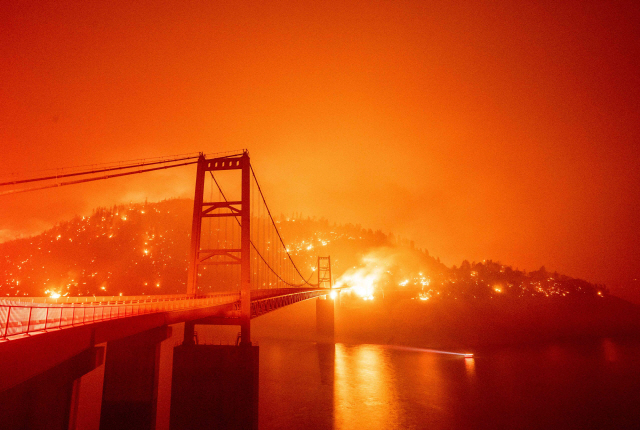 9일(현지시간) 미국 캘리포니아주 오로빌에서 발생한 산불이 ‘비드웰바’ 교량 주변 언덕으로 번지고 있다. 캘리포니아·오리건·워싱턴 등 서부 해안 3개주에서 발생한 약 40건의 대형산불로 이날 주민 수천명이 대피했다./AFP연합뉴스