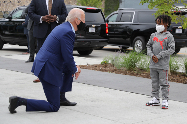 9일(현지시간) 미국 대선의 경합지인 미시간주 디트로이트를 방문한 조 바이든 민주당 대선후보가 한 쇼핑몰에서 만난 어린이와 눈높이를 맞추기 위해 한쪽 무릎을 꿇은 채 대화하고 있다. /AFP연합뉴스