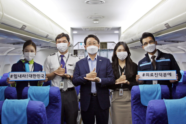 한태근(가운데) 에어부산 사장과 직원들이 코로나 19 확산 방지를 위해 헌신하는 의료진의 노고에 응원에 메세지를 보내며 덕분에 챌린지 캠페인에 동참하고 있다/사진제공=에어부산