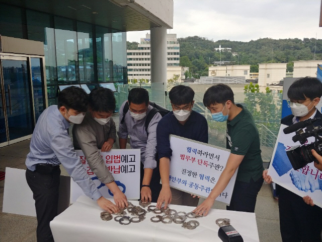 경찰 현장 수사관들이 11일 서울 용산구 남영동 경찰청 교육장 앞에서 검경 수사권 조정 관련 대통령령 수정을 촉구하며 ‘수갑반납’ 퍼포먼스를 하고 있다./사진=경찰청