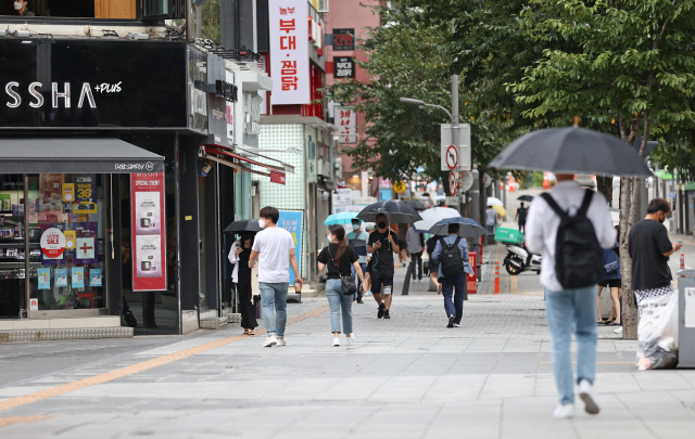 정부가 수도권 ‘사회적 거리두기’ 2.5단계 연장 여부를 두고 고심하고 있는 가운데 12일 오후 서울 서대문구 신촌연세로에서 시민들이 걸어가고 있다. /연합뉴스