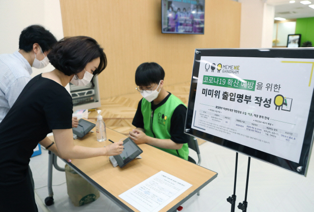 서울 강남구민이 태블릿PC를 활용한 온라인 간편 출입명부에 인적사항을 작성하고 있다./사진제공=강남구