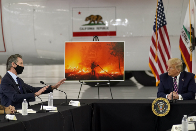 14일(현지시간) 도널드 트럼프(오른쪽) 미국 대통령이 한달 넘게 산불이 이어지고 있는 캘리포니아주의 진화기지 맥클렐런파크를 방문해 산불 관련 브리핑을 받고 있다./AP연합뉴스
