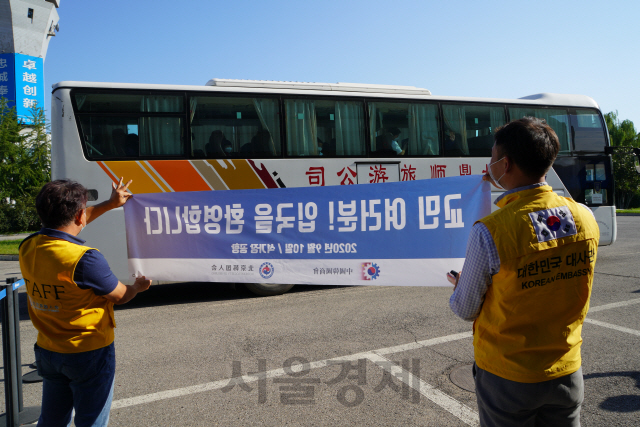 지난 10일 중국 허베이성 스자좡 공항에 전세기로 도착해 격리시설로 이동하는 우리 교민들을 주중 한국대사관과 베이징 한국인회 관계자들이 환영하고 있다. /스자좡=최수문기자