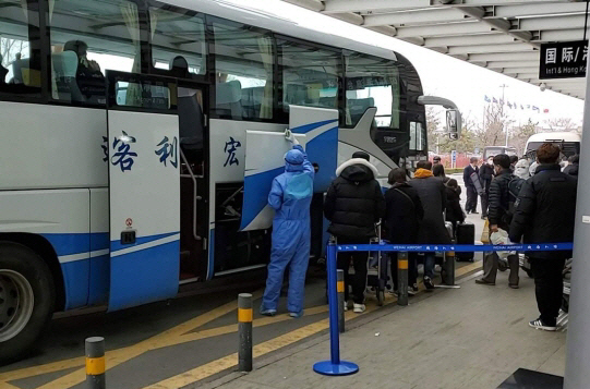 지난 2월25일 중국 산둥성 웨이하이 공항에서 한국인 입국자를 강제격리하기 위해 방역인력들이 승객들을 버스에 태우고 있다. /웨이하이 한인회 제공
