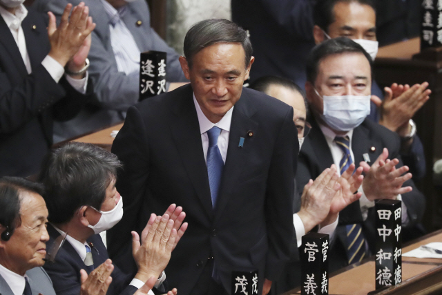 16일 일본 도쿄의 중의원 선거에서 새 총리로 선출된 스가 요시히데(가운데)가 의원들의 박수에 고개를 숙이고 있다./AP연합뉴스
