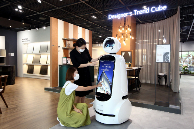 17일 서울 논현동 가구 거리에 위치한 플래그십 전시장인 ‘LG Z:IN 스퀘어’를 방문한 고객들이 전시장 입구에서 ‘LG 클로이 안내로봇’으로부터 전시장 및 전시제품에 대해 설명을 듣고 있다. /사진제공=LG하우시스