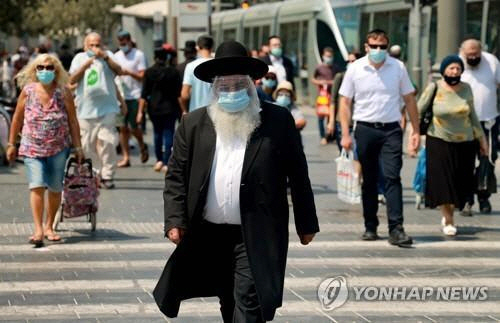 예루살렘의 한 거리에서 마스크를 쓴 이스라엘 시민들이 걷고 있다./AFP연합뉴스