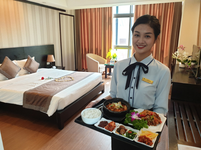 베트남 하노이에 있는 탑호텔 객실에서 한 직원이 한식 메뉴를 들고 사진 촬영을 하고 있다.