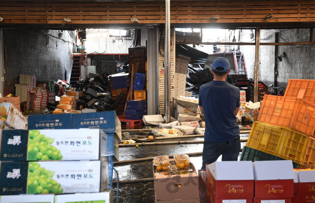 추석을 열흘 앞둔 21일 새벽 화재가 발생한 서울 동대문구 청량리 청과물시장에서 한 상인이 화재현장을 보고 있다./성형주기자 2020.09.21