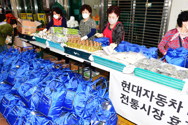 현대차 노사는 22일 울산 북구 호계시장에서  추석맞이 전통시장 기 살리기 나눔사업을 펼쳤다, 이날 상인들은 현대차 노사가 제작해 전달한 에코백으로 효꾸러미를 만들어 울산사회복지 공동 모금회에 전달 했다. /사진제공=현대자동차