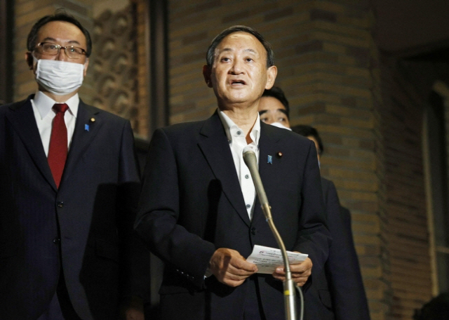 스가 요시히데(오른쪽) 일본 총리가 20일 밤 관저에서 취재진을 만나 도널드 트럼프 미 대통령과 전화로 회담한 내용을 설명하고 있다./교도연합뉴스