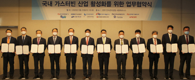 두산중공업 및 공기업 발전자회사 대표와 관계자들이 23일 서울 그랜드인터콘티넨탈호텔에서 업무협약 체결서를 보이고 있다./사진제공=두산중공업